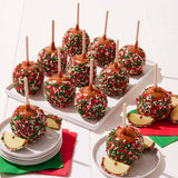 Caramel apples with Christmas sprinkles on a white surface