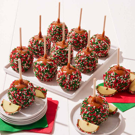 Caramel apples with Christmas sprinkles on a white surface