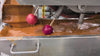 An animation of how caramel apples are made. Apples are dipped in caramel. Excess caramel is spun off. Finally, the apples are rolled in nuts.